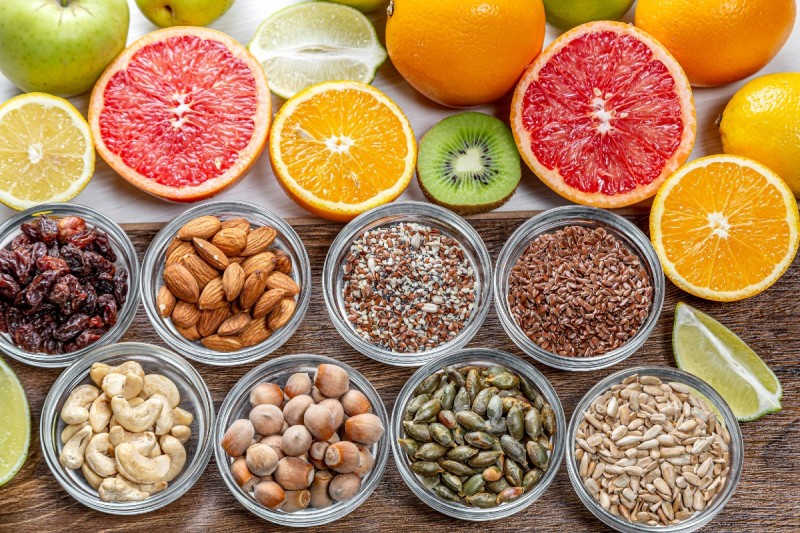 An assortment of citrus fruits and nuts.