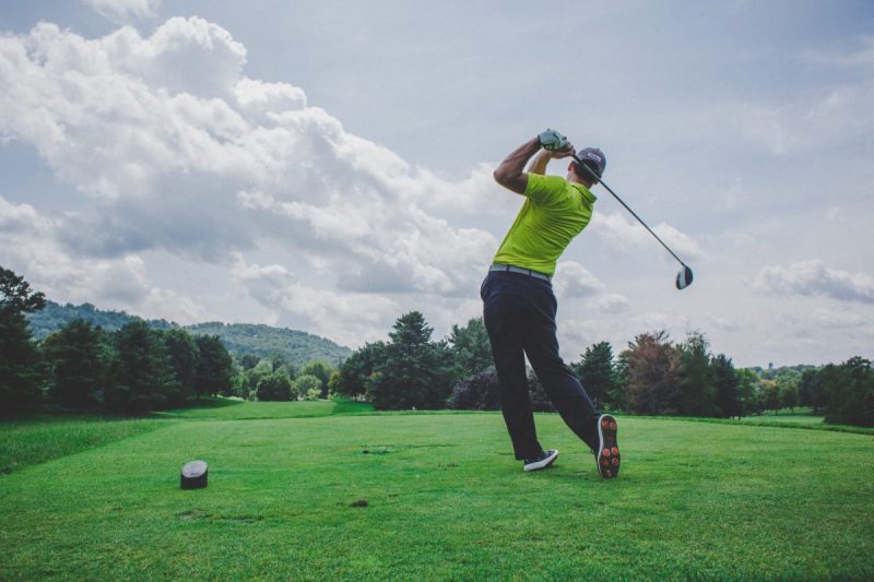 A person hitting a shot on the golf course.