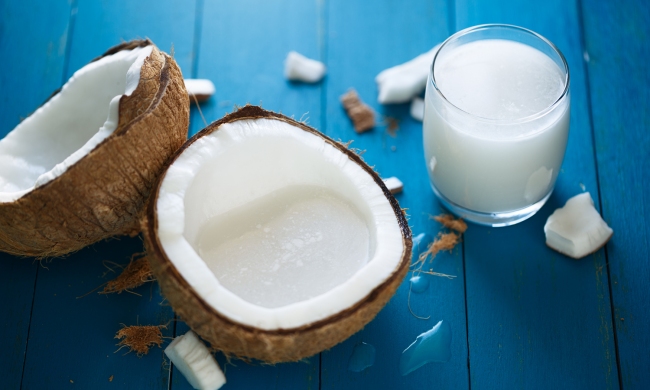 A coconut on a table with the milk